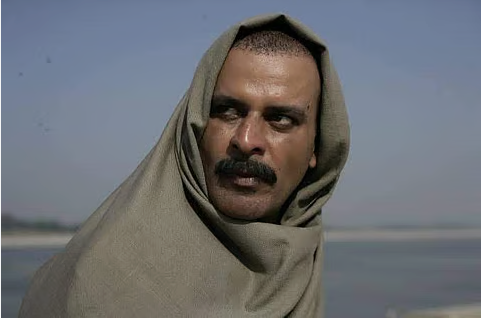 A man wrapped in a shawl, looking into the distance